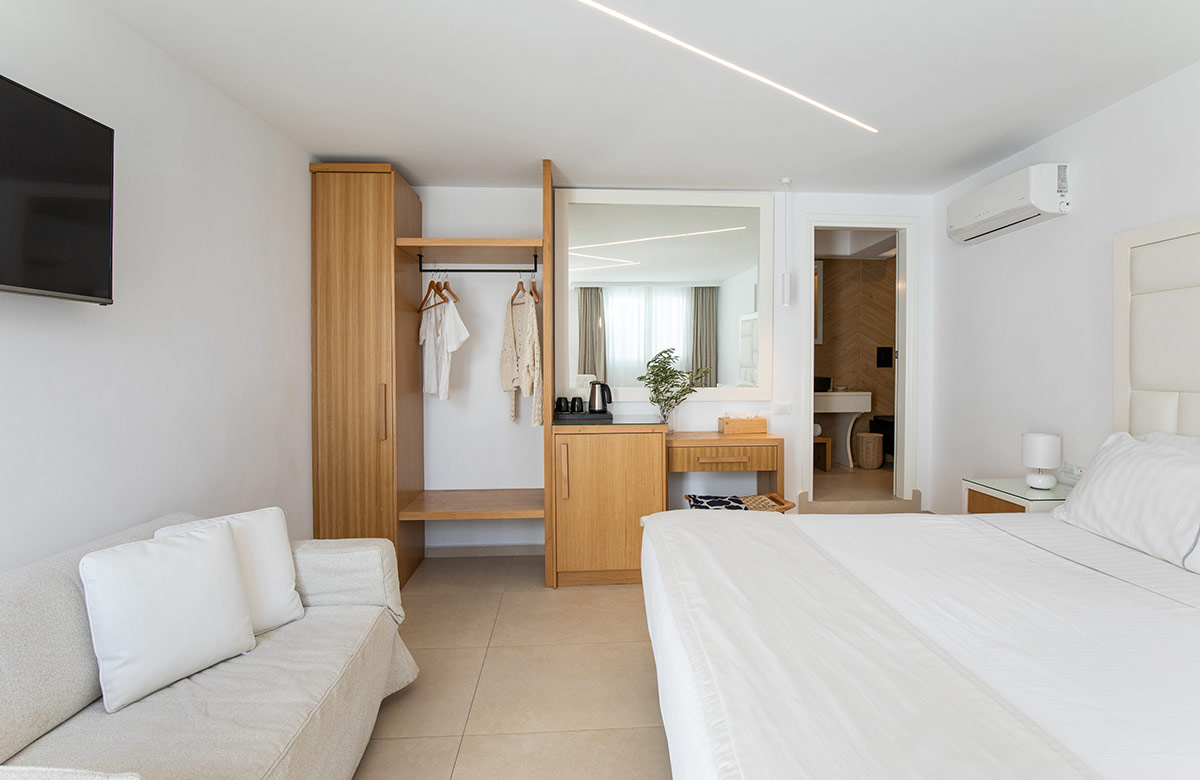 Classic Room interior with open wardrobe, vanity area and bathroom view at Damianos Hotel Mykonos