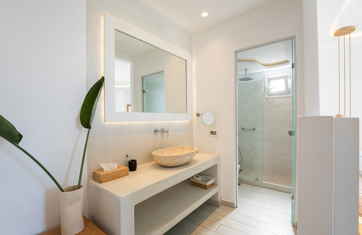 Open air bathroom in a deluxe hotel room in Mykonos Town with walk-in shower and minimal Cycladic design