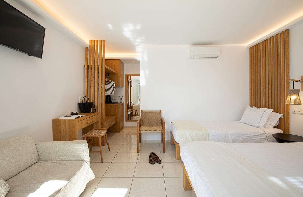 Twin bed layout with sofa and minimalist interior in Mykonos Town hotel room