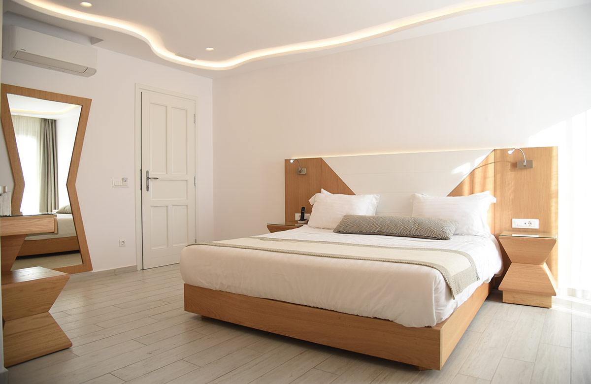 Minimal bedroom with wooden details and soft lighting at Damianos Hotel in Mykonos Town