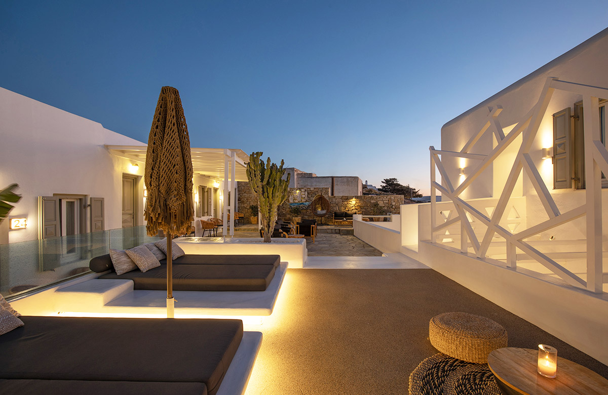 Outdoor lounge area at Damianos Hotel in Mykonos Town during the evening with soft lighting and Cycladic design