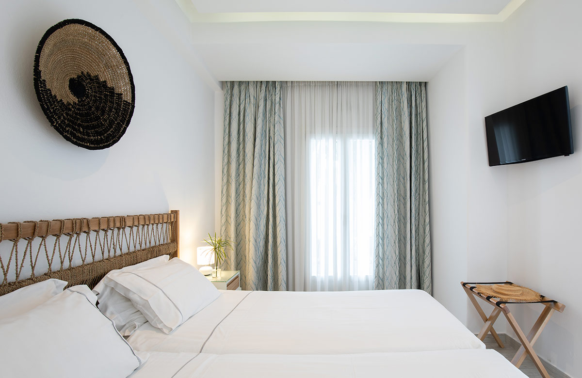 Classic Room interior with woven headboard, soft textiles and calm design at Damianos Hotel Mykonos Town