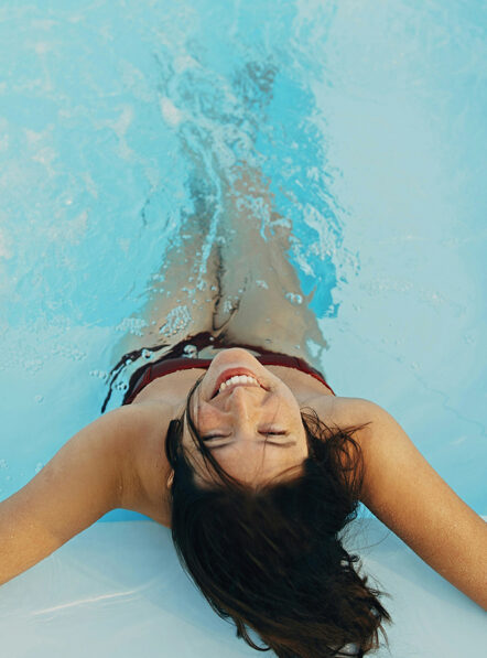 Woman relaxing in the outdoor pool at Damianos Mykonos Town hotel