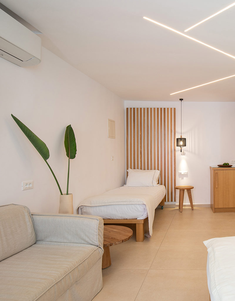 Interior of a triple standard room with single bed and seating area in Mykonos Town hotel