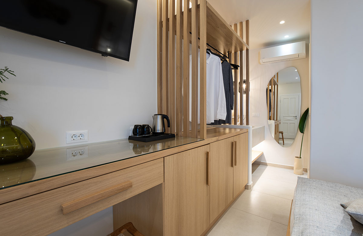 Hotel room in Mykonos Town at Damianos Hotel with natural wood furnishings, open wardrobe partition and modern amenities