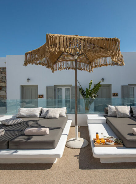 Poolside sunbeds at Damianos Hotel in Mykonos Town with shaded lounge area